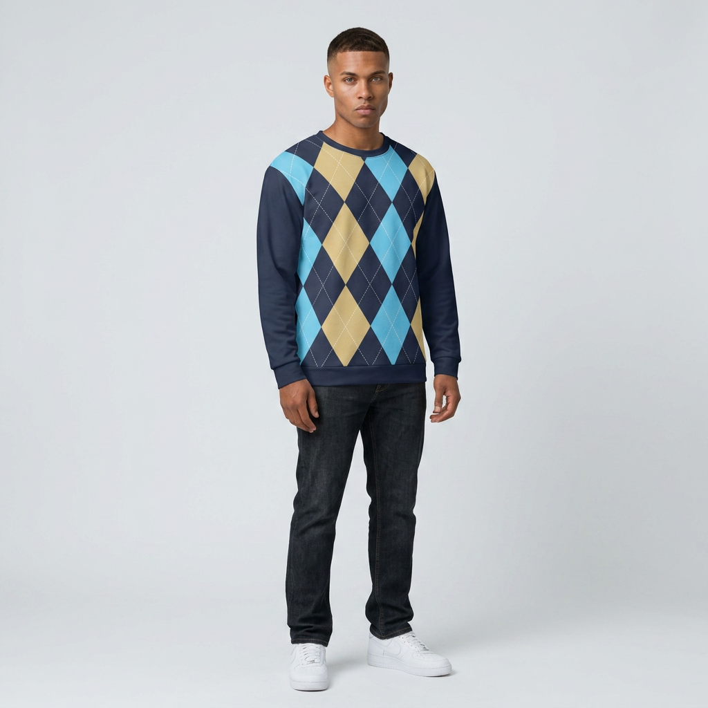 A man modeling a long-sleeve crewneck sweater with a navy blue base and an argyle pattern in light blue, tan, and navy, paired with dark jeans and white sneakers against a light gray studio background.