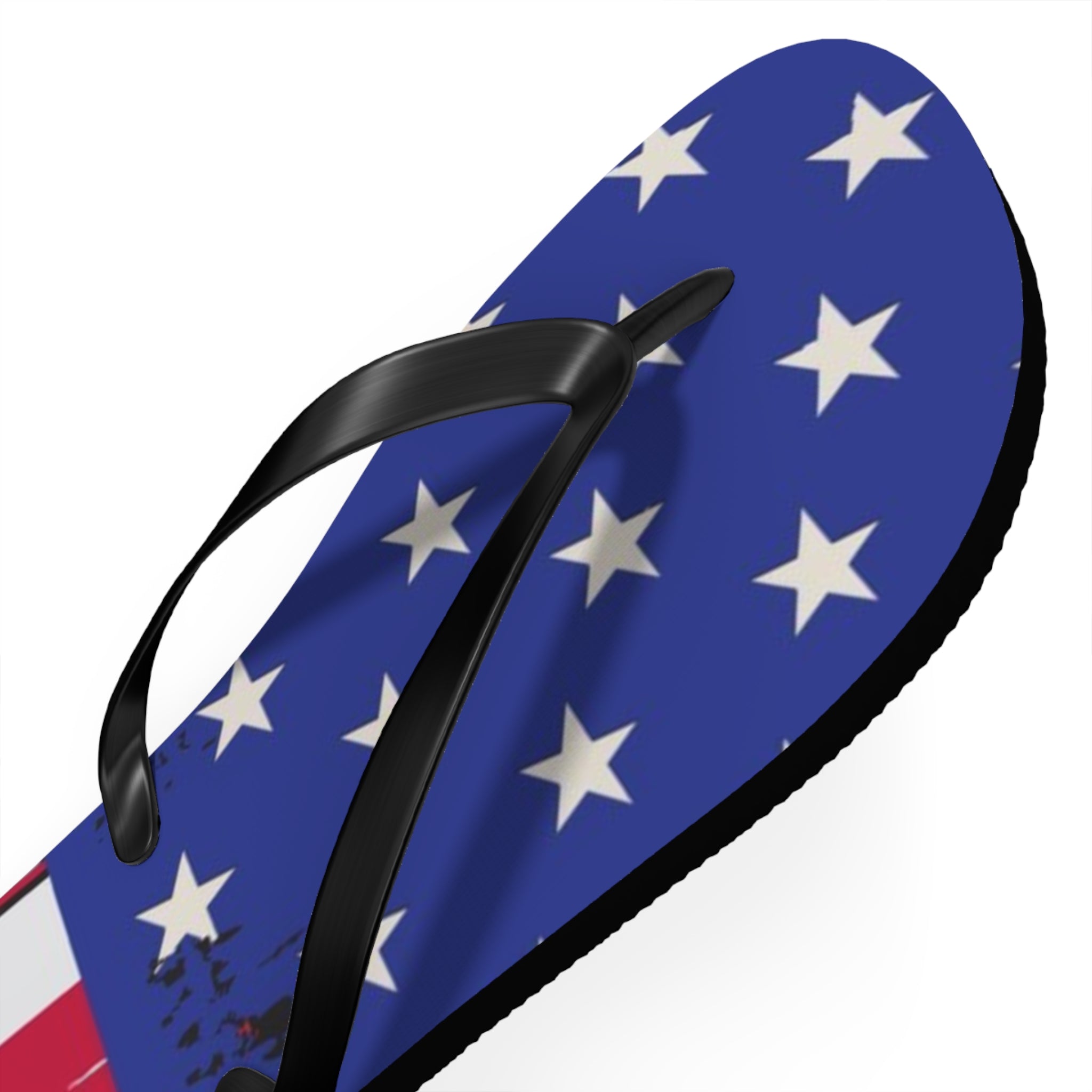 A single flip-flop sandal shown on a plain white background. The footbed has an American flag-inspired design with a blue field, white stars, and a small red-and-white section at the heel, while the thong strap is black.