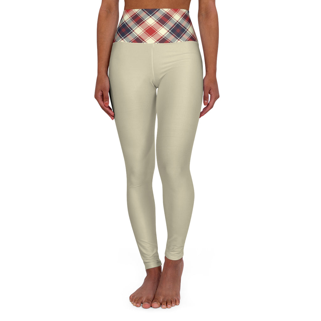 A model wearing high-waisted leggings in a light beige color with a red, navy, and cream plaid waistband, shown from the waist down on a white background.