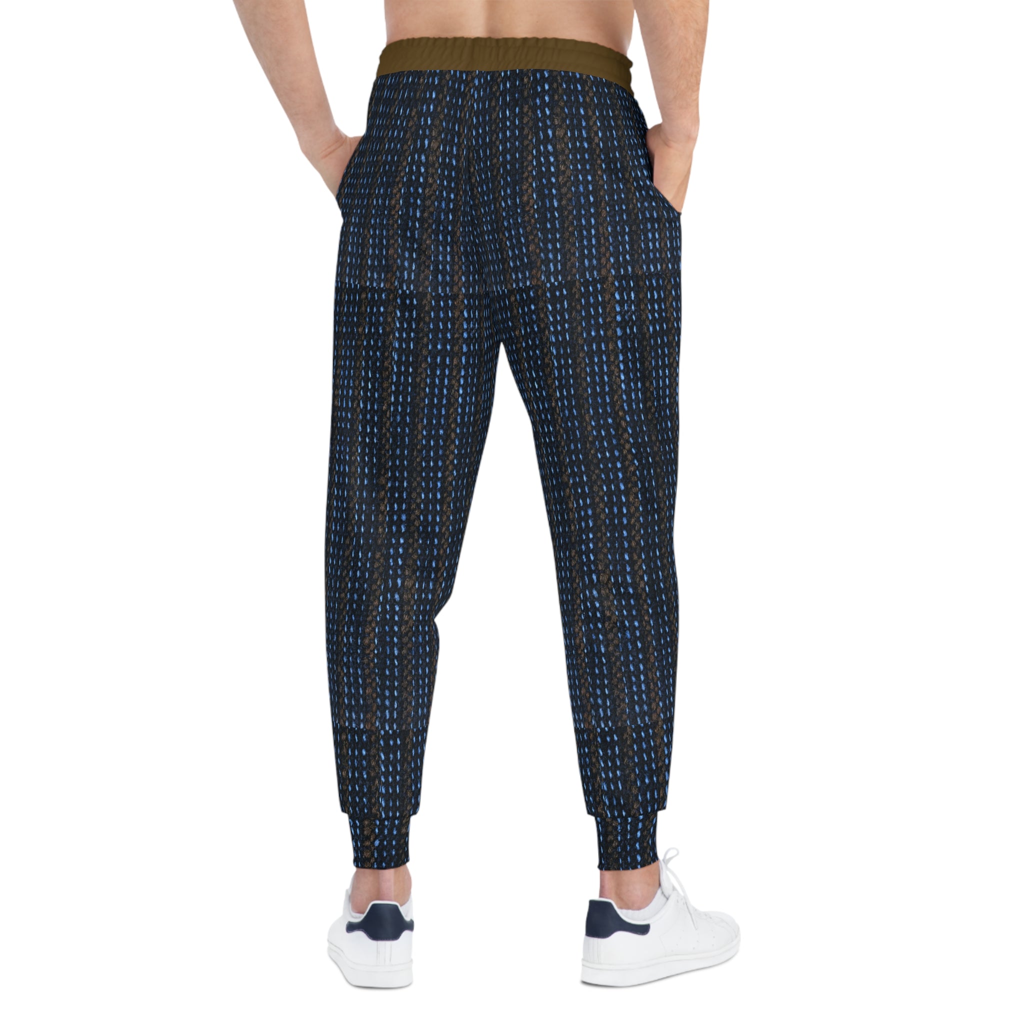 A person shown from the back wearing patterned jogger-style pants with a dark navy base and small blue and white vertical dotted lines, plus a contrasting olive-brown waistband and white sneakers.