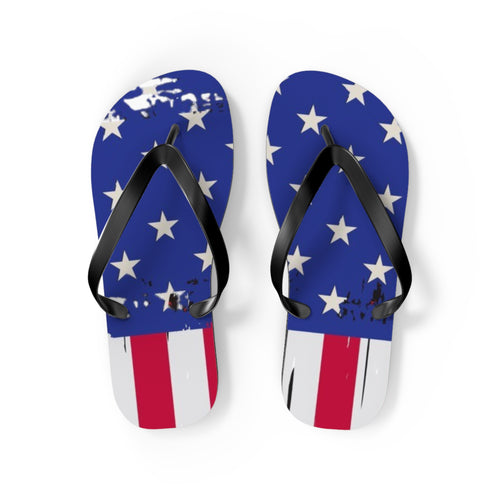 A pair of flip-flop sandals with a distressed American flag design, featuring blue feet with white stars and red and white stripes, and black straps, shown on a white background.