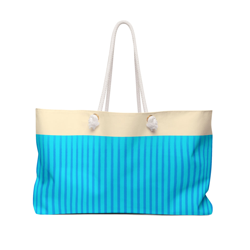 A tote bag with a cream top section and a bright blue lower section featuring vertical stripes, complete with two white rope handles.