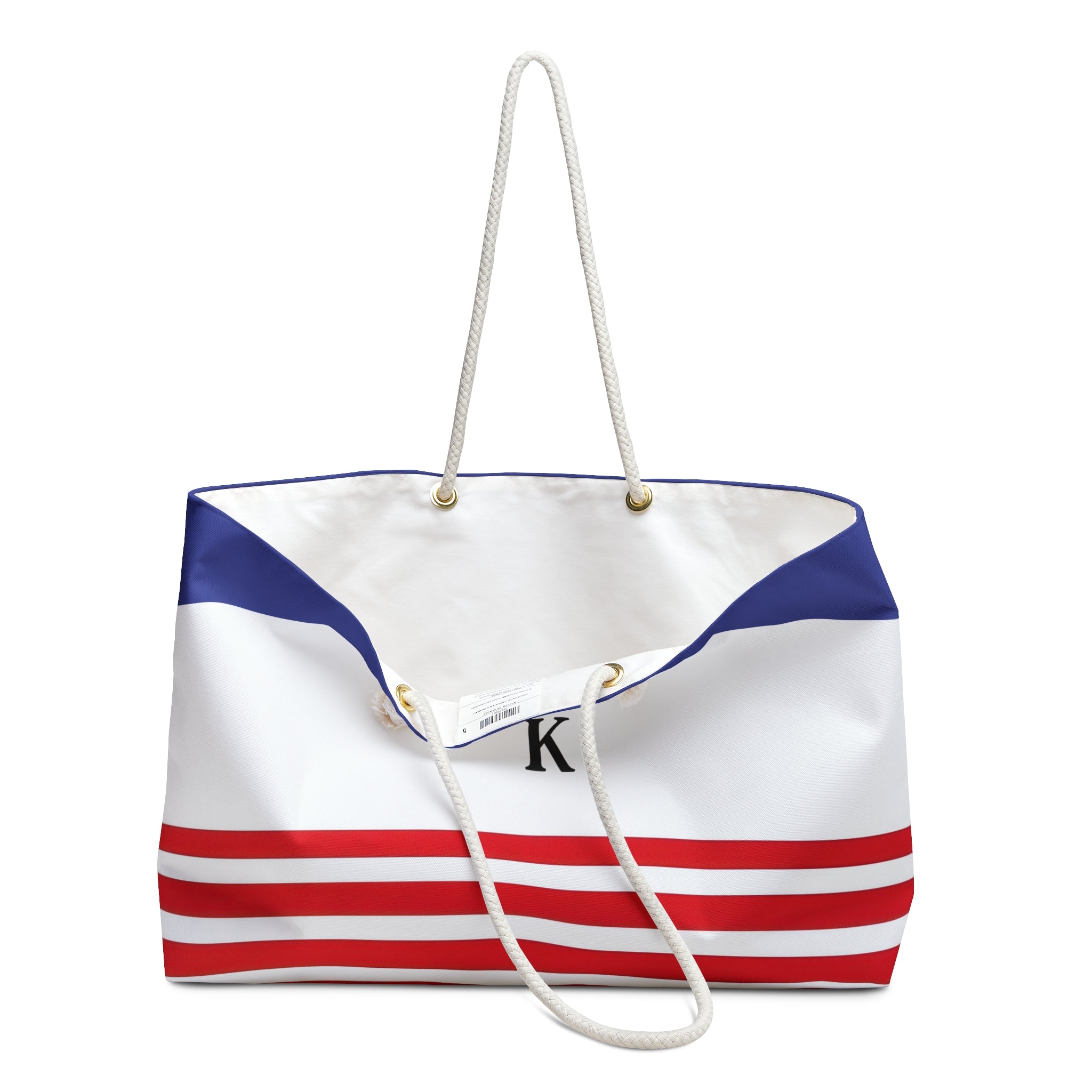 A canvas tote bag with a white, blue, and red nautical stripe design, featuring white rope handles and a black monogram 'K' on the front.