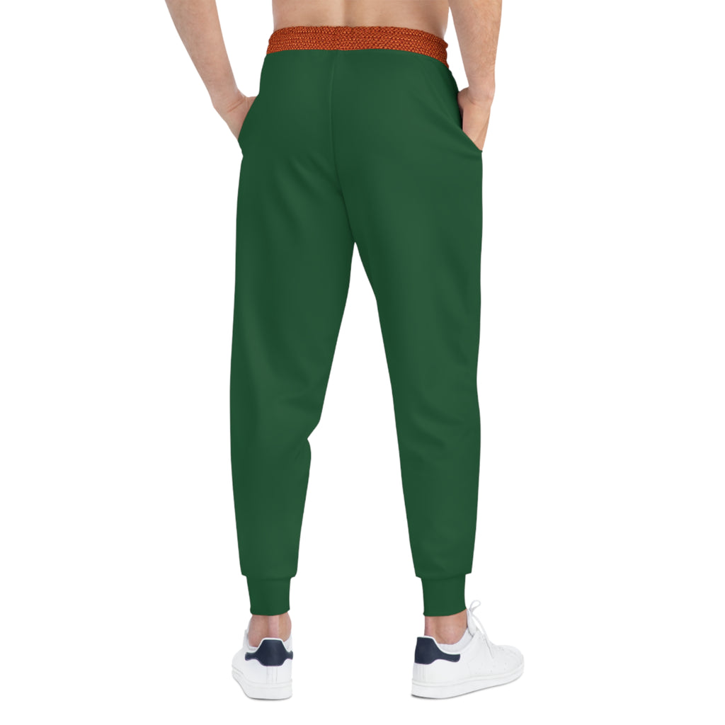 A person shown from the back wearing dark green jogger-style pants with a textured orange-brown elastic waistband and white sneakers, on a plain white background.