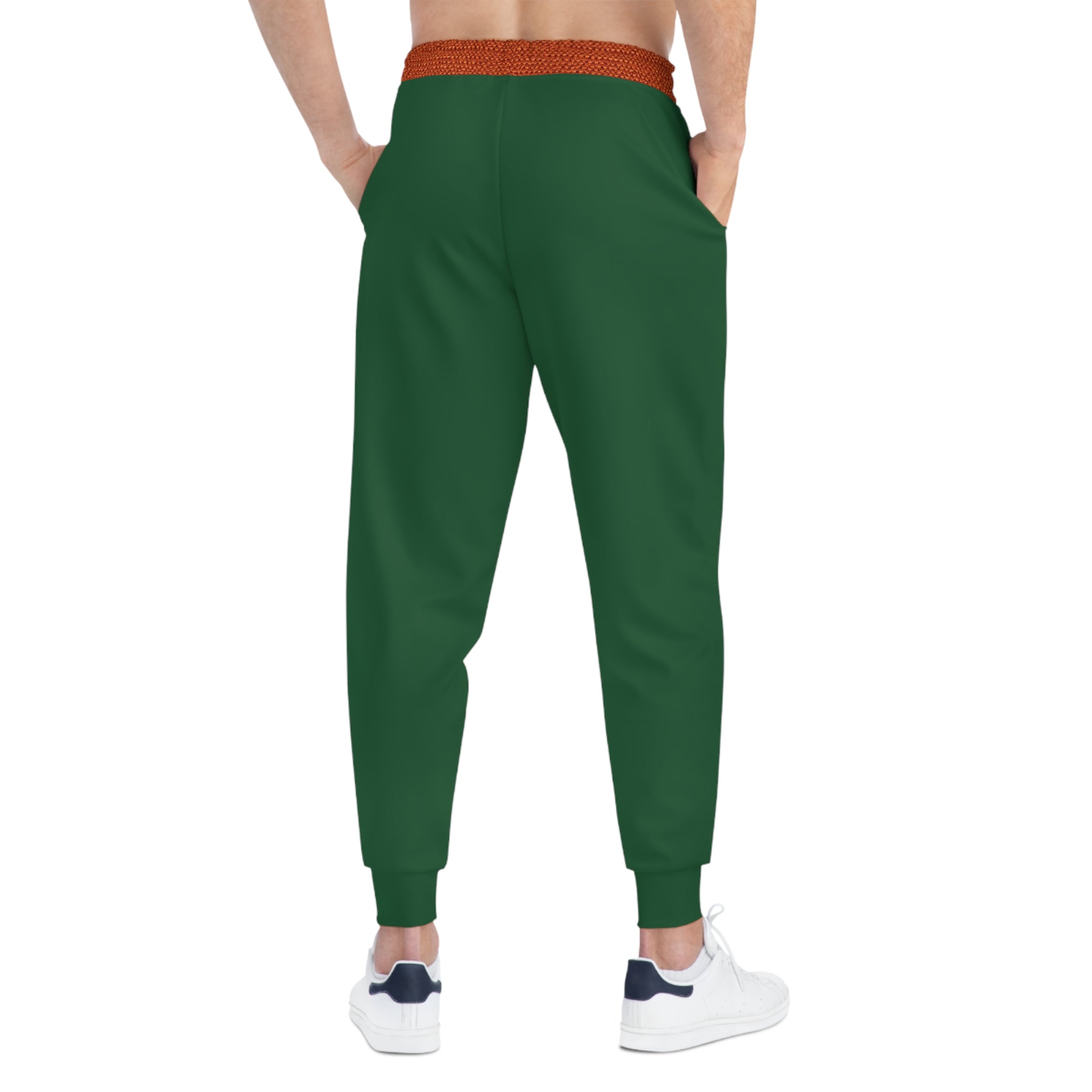 A person shown from the back wearing dark green jogger-style pants with a textured orange-brown elastic waistband and white sneakers, on a plain white background.