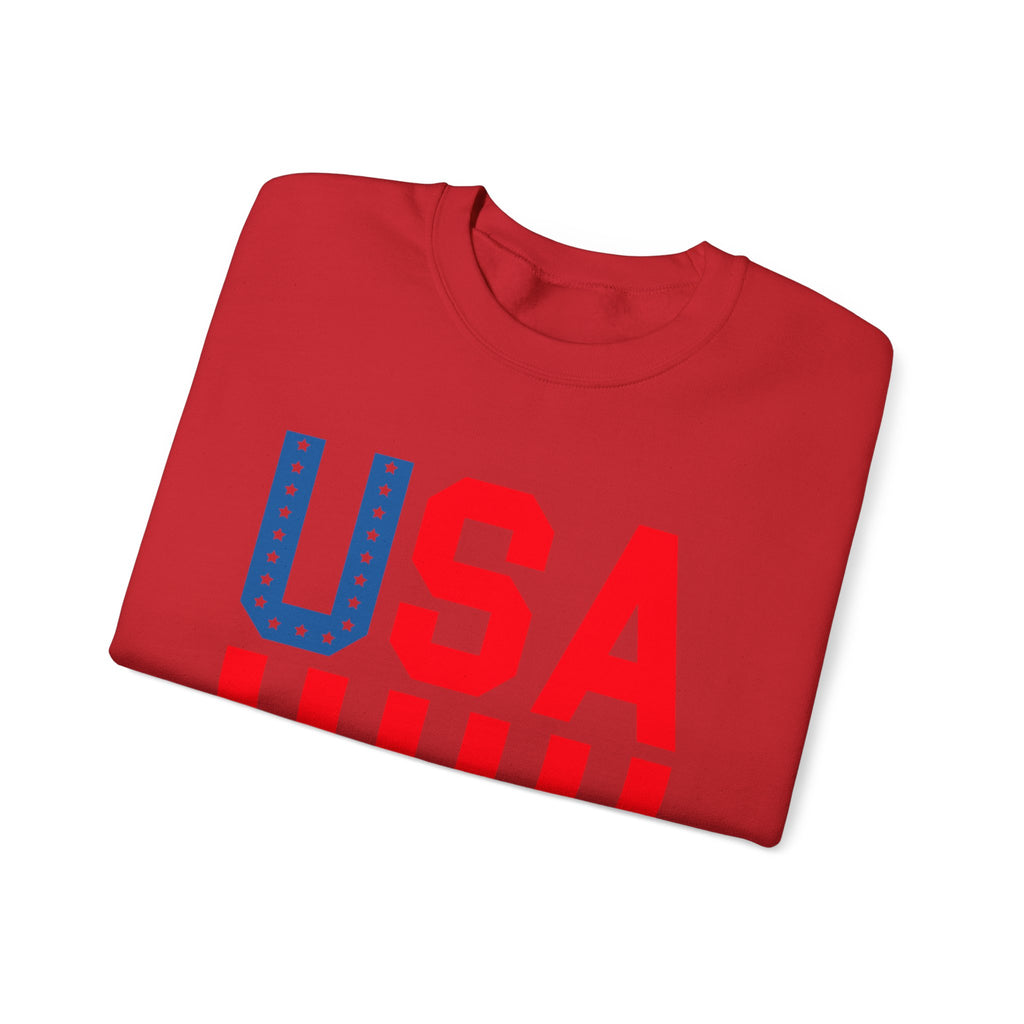 A folded red crewneck t-shirt featuring a large 'USA' graphic on the front. The letter 'U' is filled with blue stars and a blue border, while 'S' and 'A' are solid red.