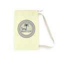 A pale yellow canvas drawstring bag with a navy blue circular graphic that reads 'BEACH CLUB EST. HOLIDAY' with a palm tree and lounge chair illustration.