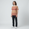 Person wearing a striped t-shirt and dark jeans on a plain background