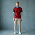 Man wearing a red polo shirt and beige pants against a gray background