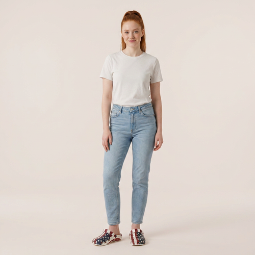 Person wearing a white t-shirt and light blue jeans on a beige background