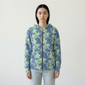 A model wearing a blue zip-up hoodie with a green and light purple floral pattern, paired with light-wash jeans, against a plain off-white background.