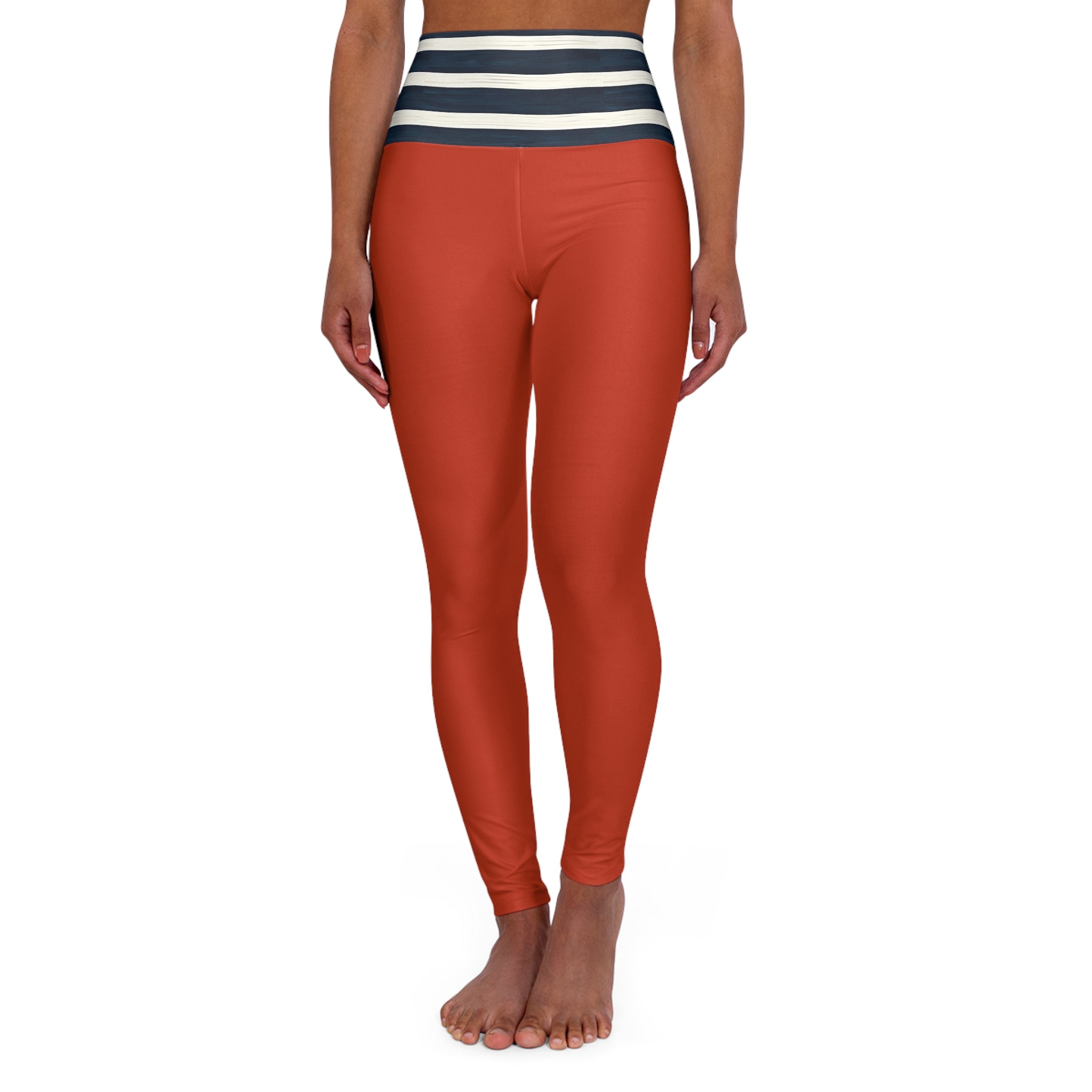 A model wearing high-waisted rust-orange leggings with a navy and cream striped waistband, shown from the waist down against a plain white background.
