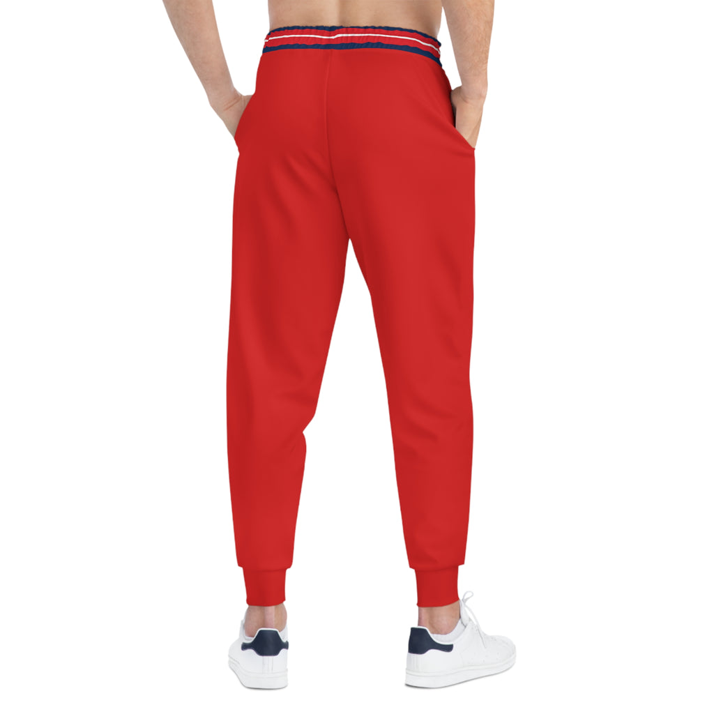 Red jogger pants with a navy and red striped elastic waistband, shown on a model from the back against a white background.