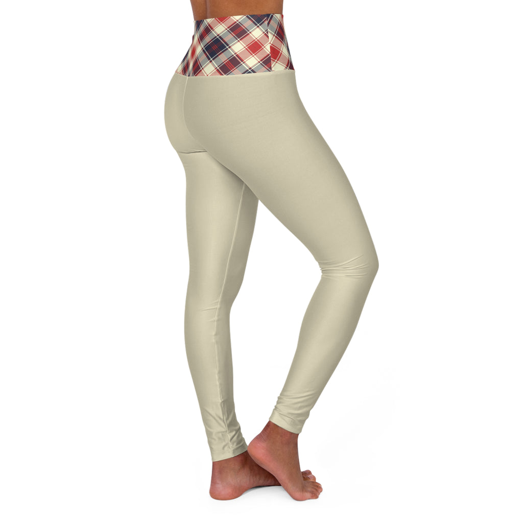 A person modeling high-waisted leggings against a plain white background. The leggings are a light beige/cream color with a red, navy, and white plaid waistband.