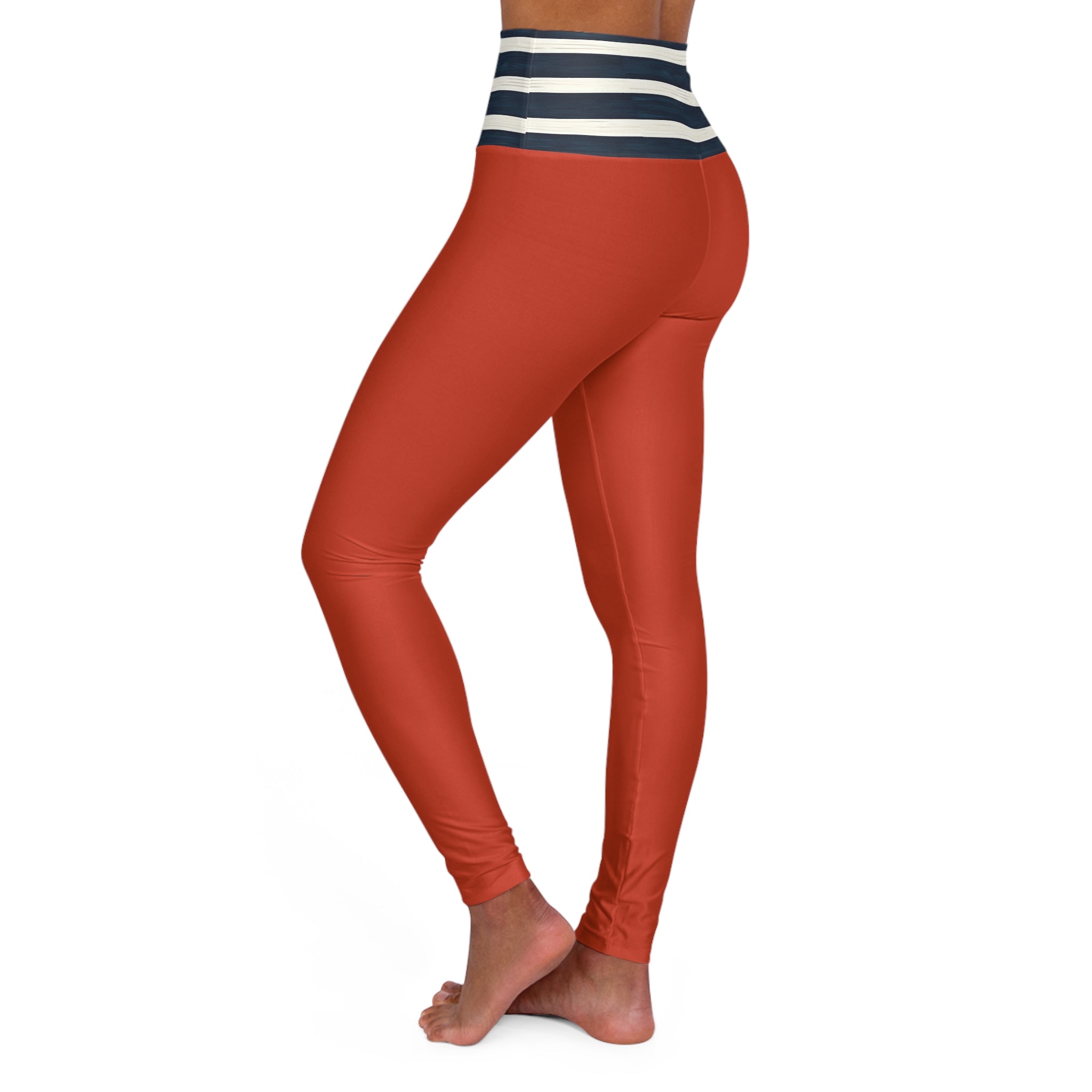 A person wearing high-waisted leggings in a rust orange color, featuring a navy and white striped waistband, shown from a side-rear angle against a plain white background.