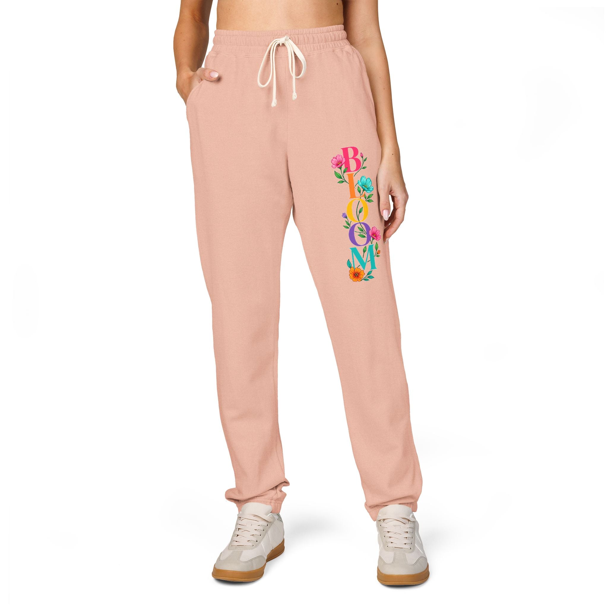 Pink sweatpants with colorful text design on a white background