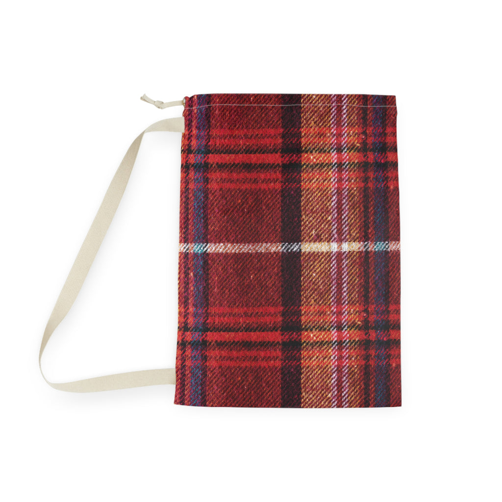 A small zippered pouch with a red and orange tartan plaid pattern and a cream-colored strap, shown on a plain white background.