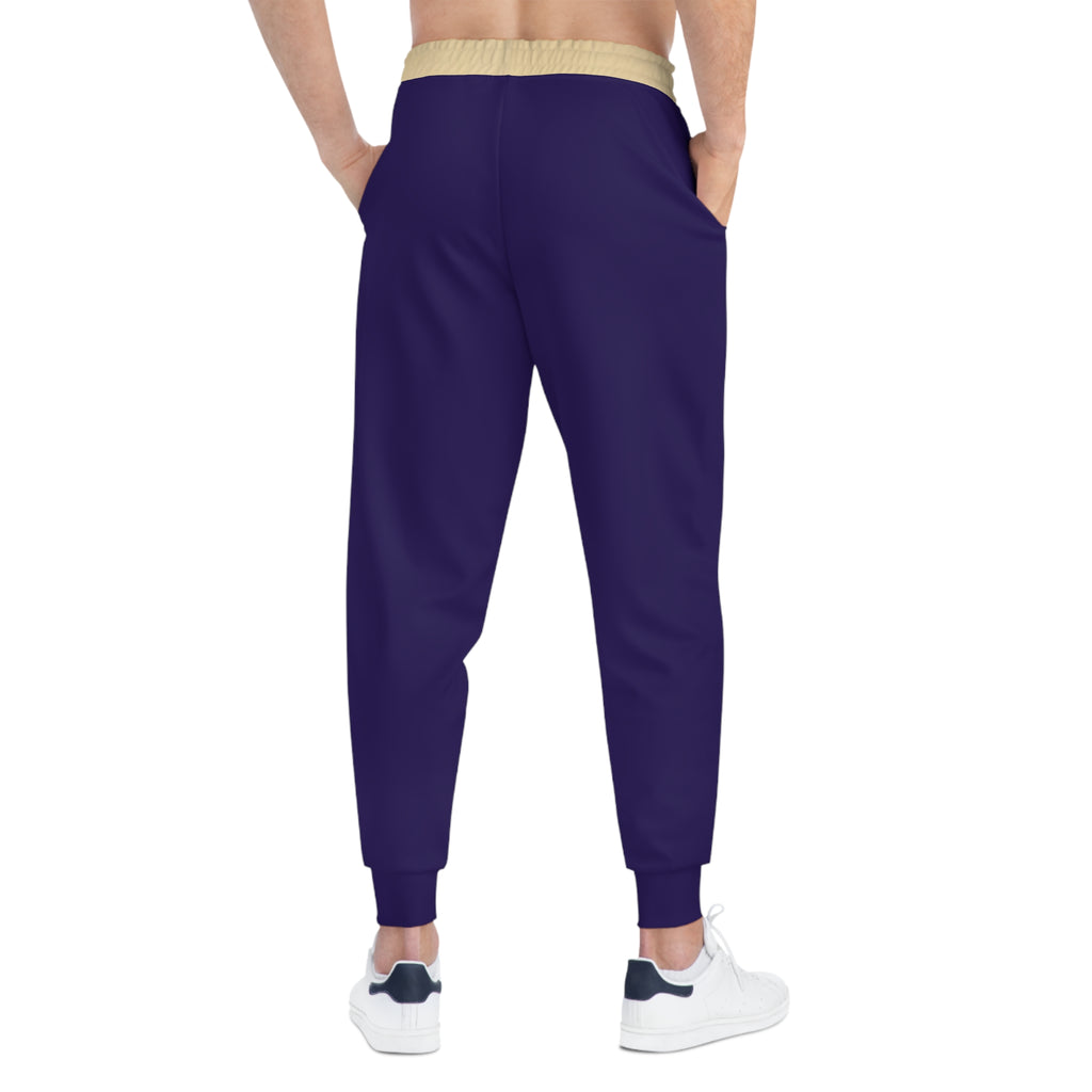 A person shown from the back wearing dark purple jogger-style pants with a beige elastic waistband and white sneakers, against a plain white background.