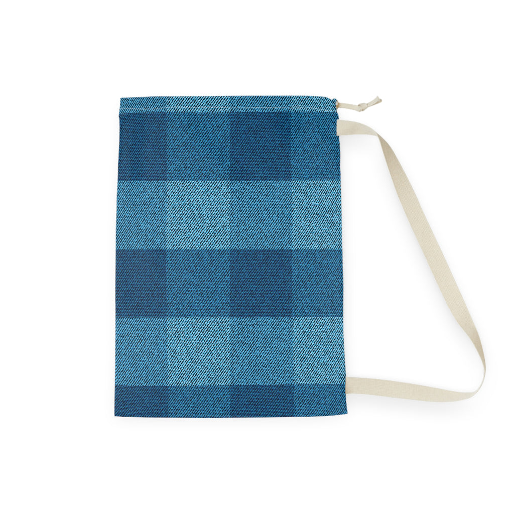 A fabric drawstring pouch featuring a blue and navy buffalo plaid pattern, with a beige strap and zipper pull, shown on a plain white background.