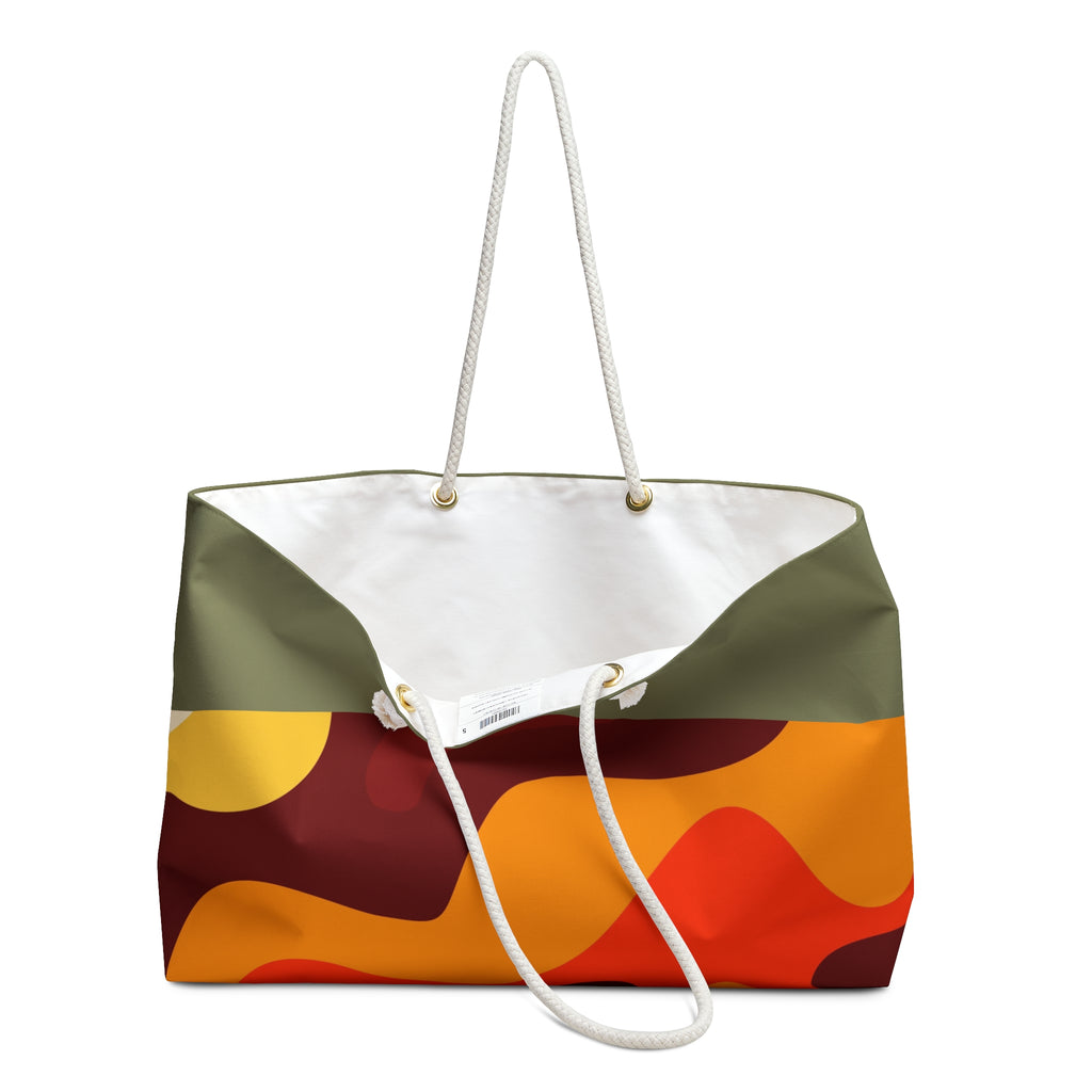 A canvas tote bag with a retro wavy abstract pattern in olive green, orange, red, and yellow, featuring a white canvas interior and white rope handles.