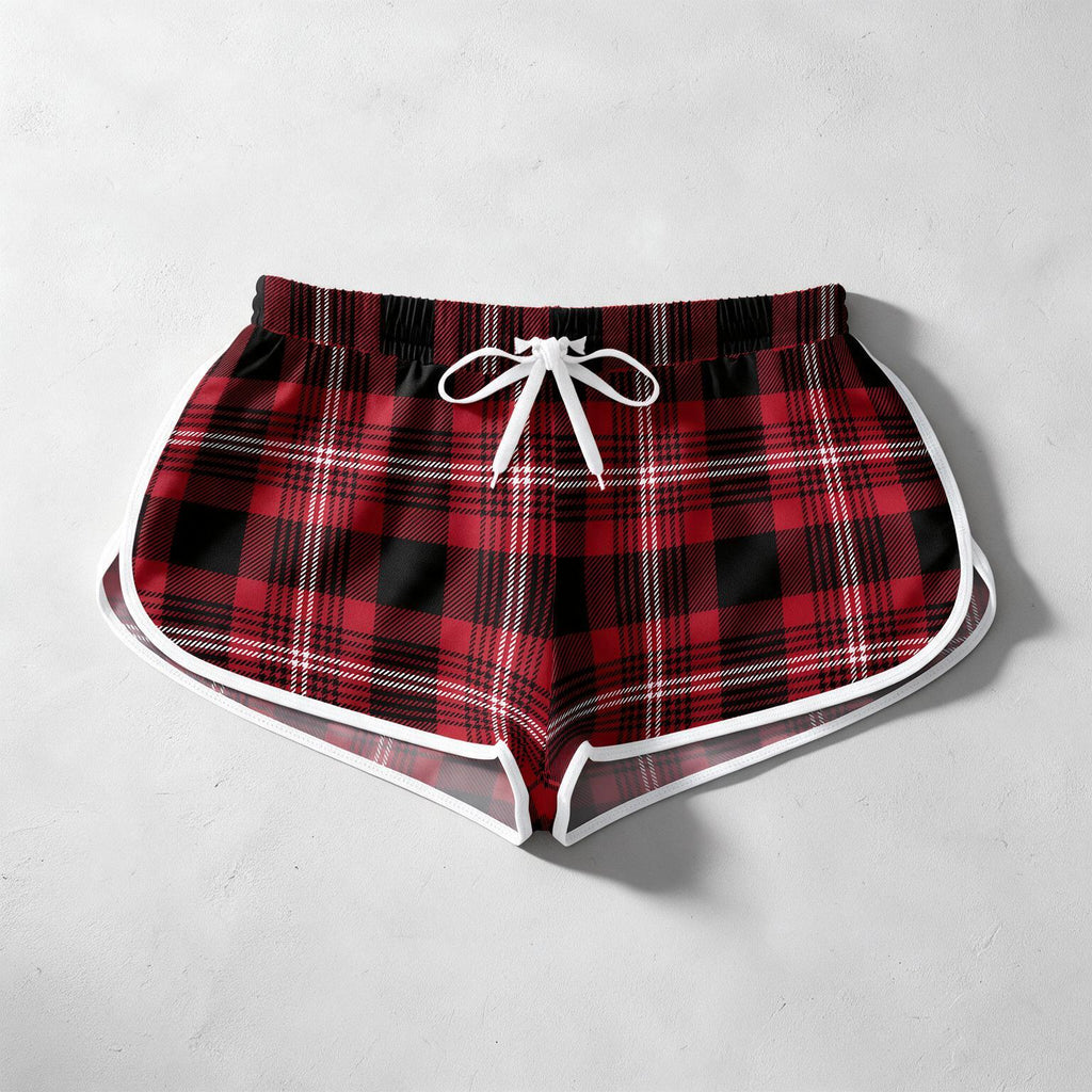 Red and black plaid shorts with a white drawstring and white piping trim, laid flat on a light gray textured background.