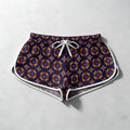 Patterned athletic shorts with a white drawstring and white piping trim, laid flat on a light gray textured background.
