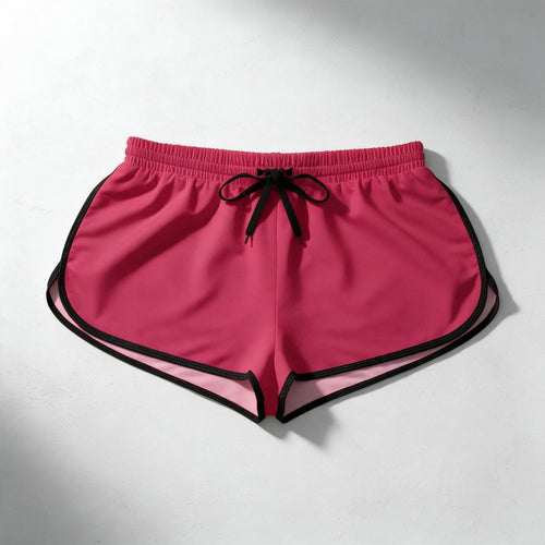 Bright pink athletic shorts with black trim and a black drawstring, laid flat on a light gray surface.
