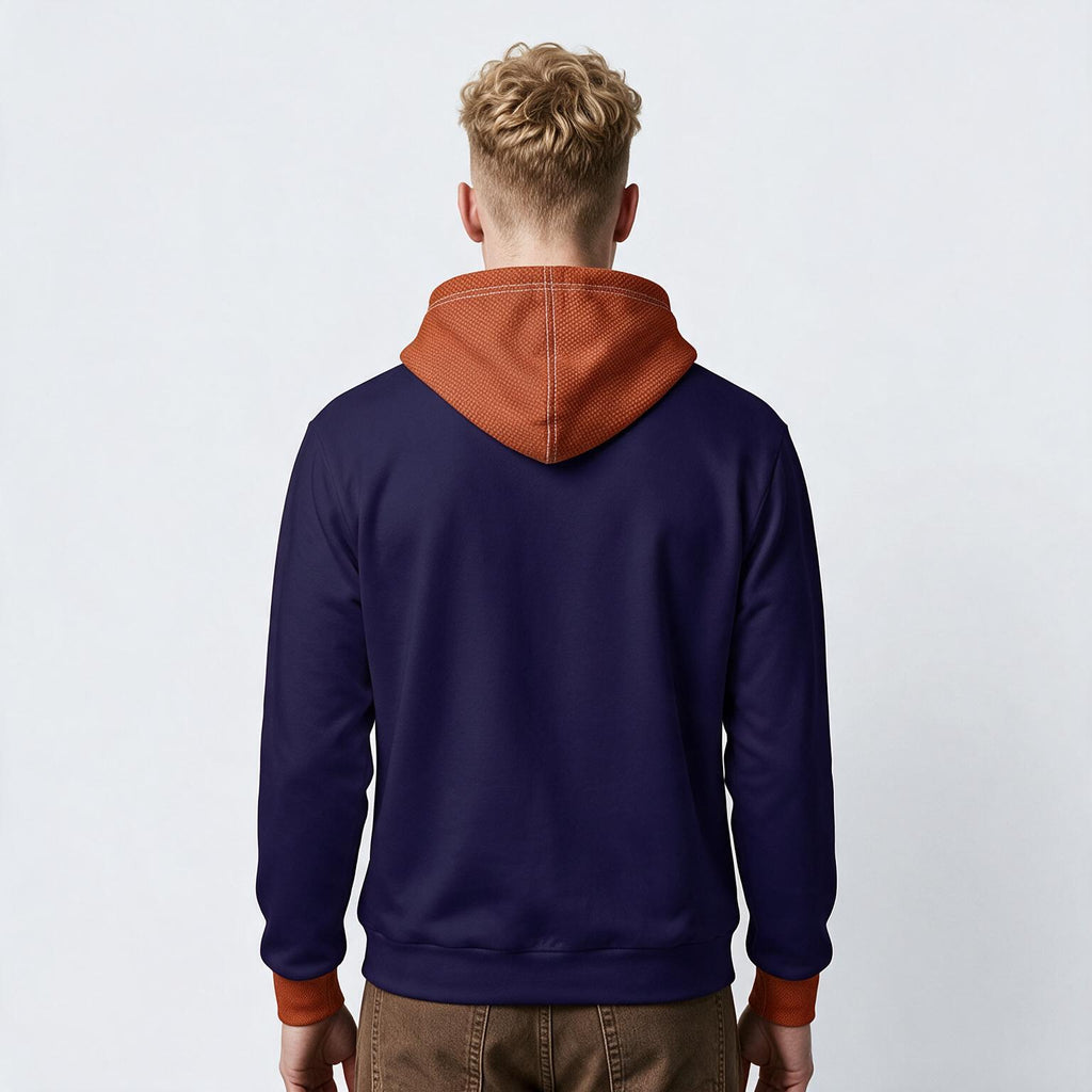 A man viewed from behind wearing a navy blue hoodie with a contrasting rust-orange hood and cuffs, paired with brown pants, against a plain light gray background.
