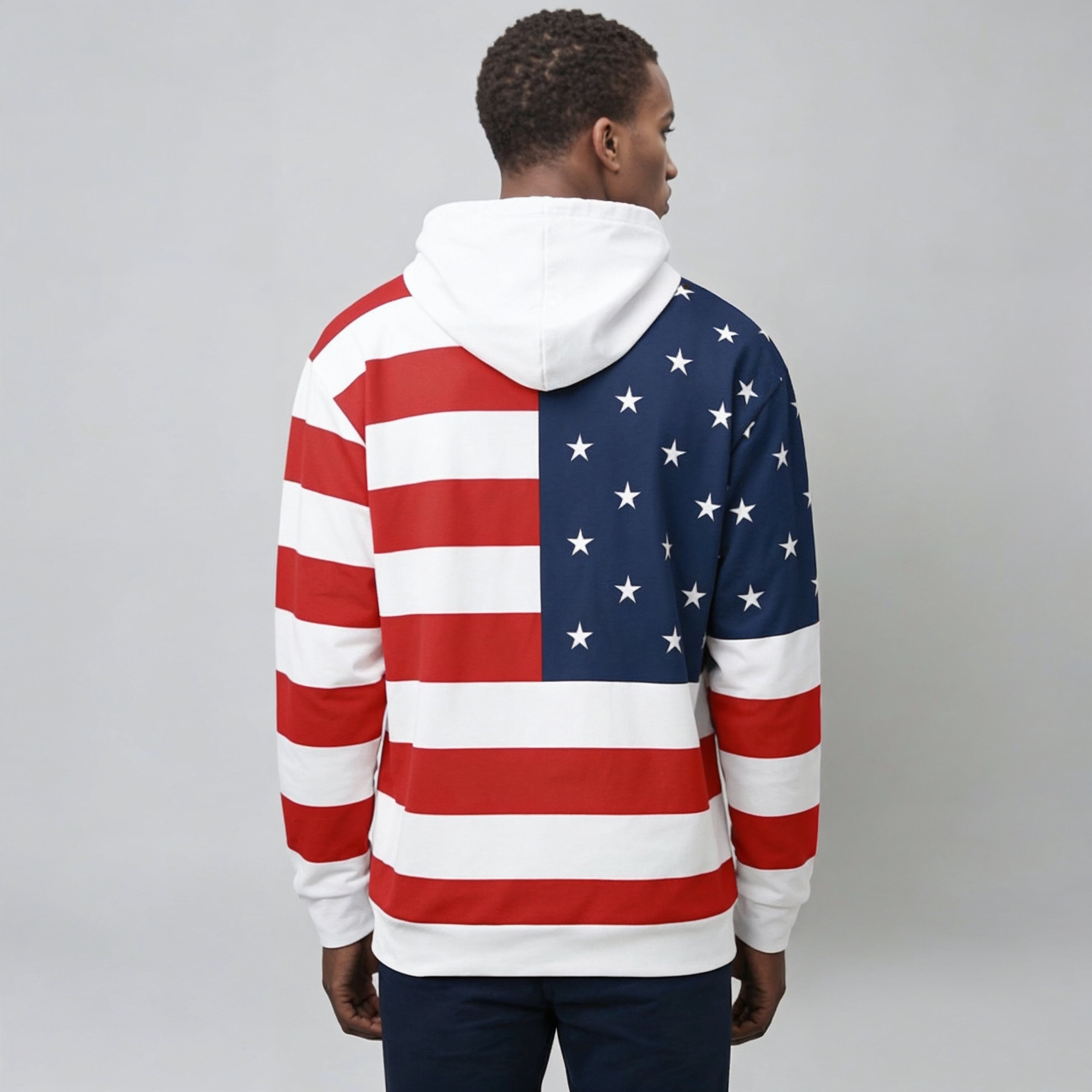 Person wearing a hoodie with an American flag design on a plain background