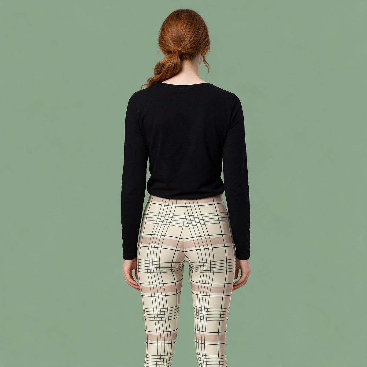 A woman is shown from behind wearing a black long-sleeve top and cream-colored plaid pants against a solid sage green background.