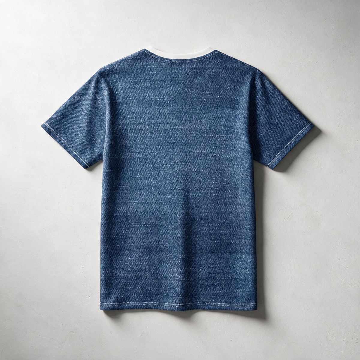 A blue short-sleeve t-shirt with a textured, heathered fabric finish, shown from the back against a neutral light gray background.