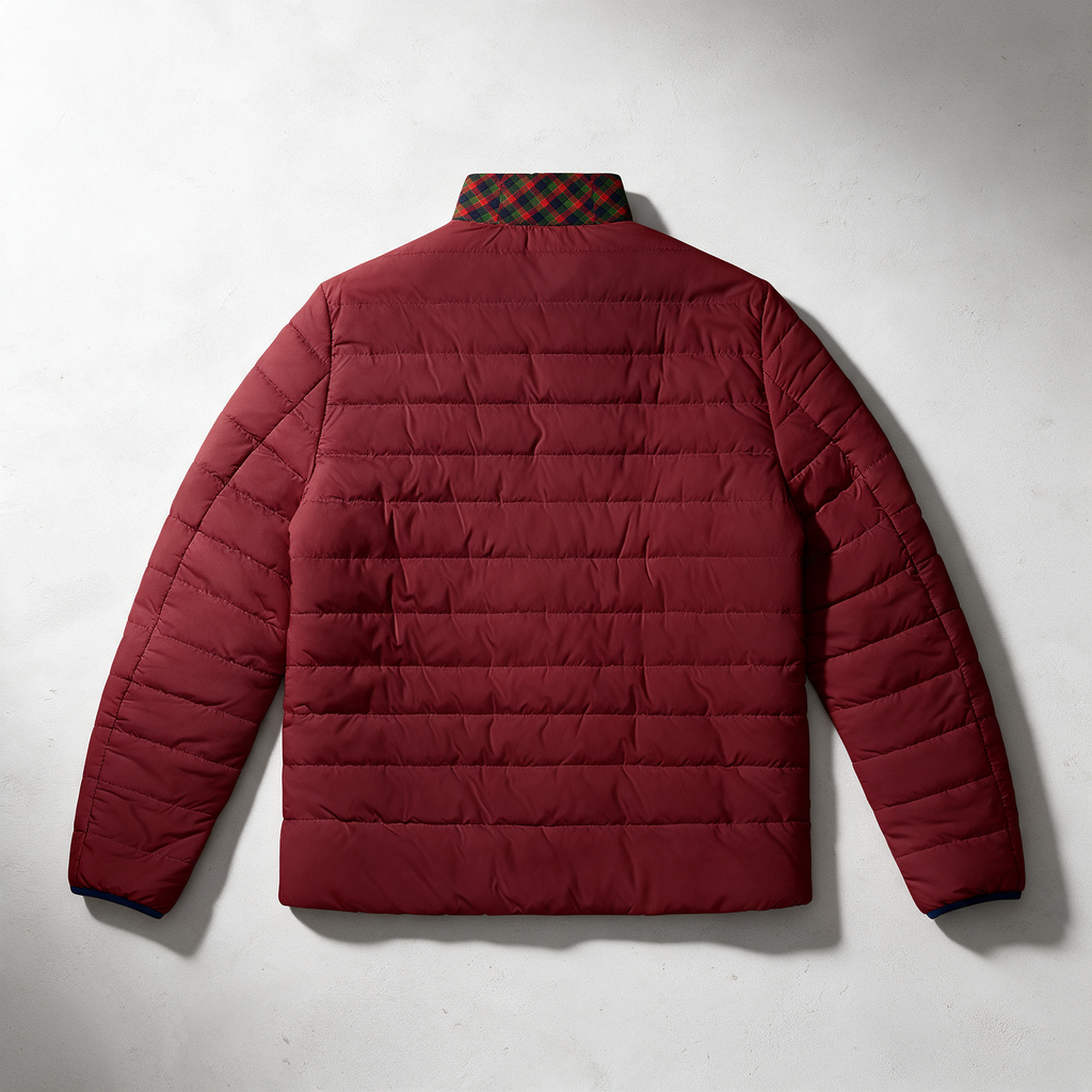 A burgundy quilted puffer jacket shown from the back, laid flat against a light gray textured background. The jacket features horizontal quilting, long sleeves, and a plaid patterned collar in red and green.