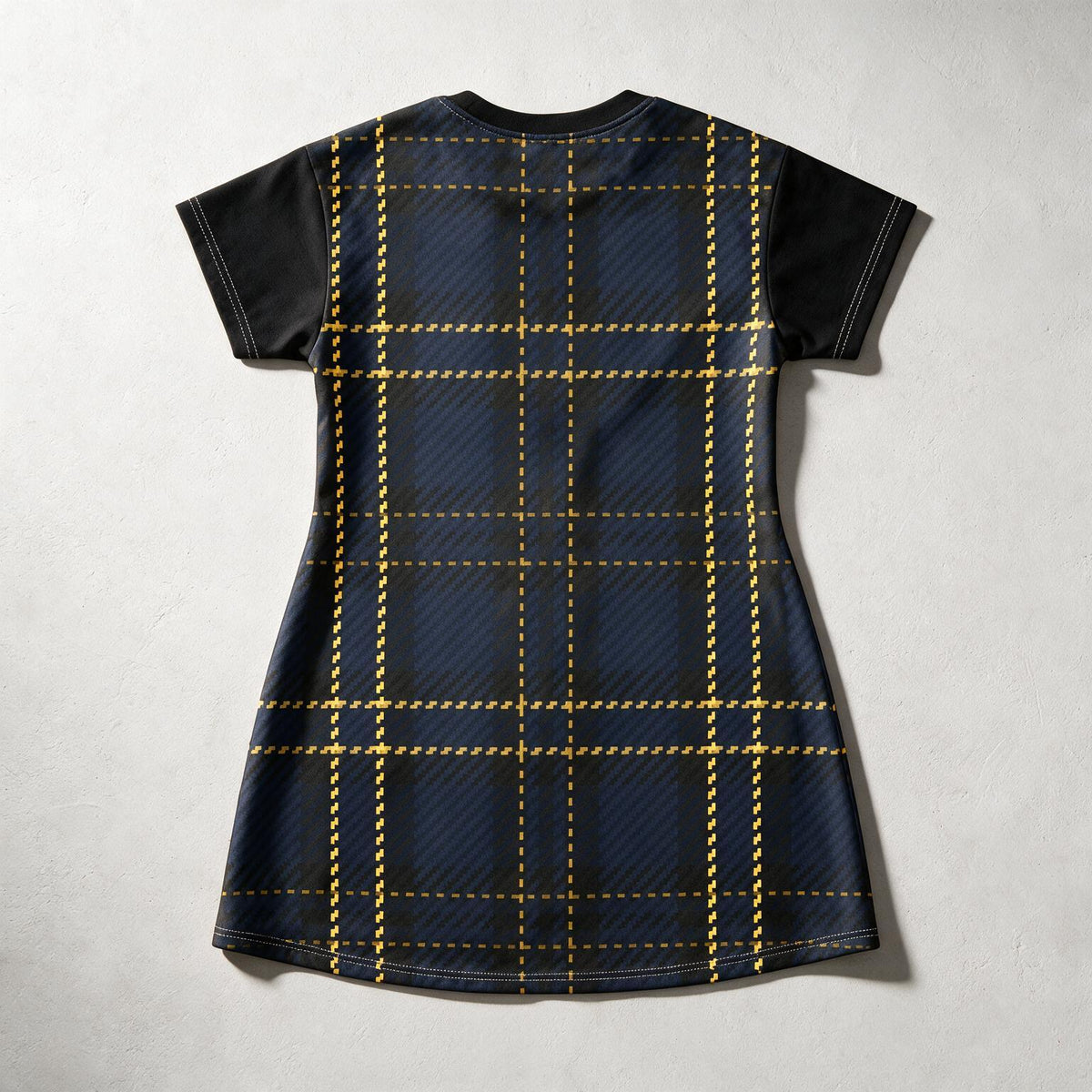 A short-sleeve tunic dress shown from the back, featuring a dark navy blue and black plaid pattern with gold dashed grid lines and solid black sleeves, laid flat on a light gray textured background.