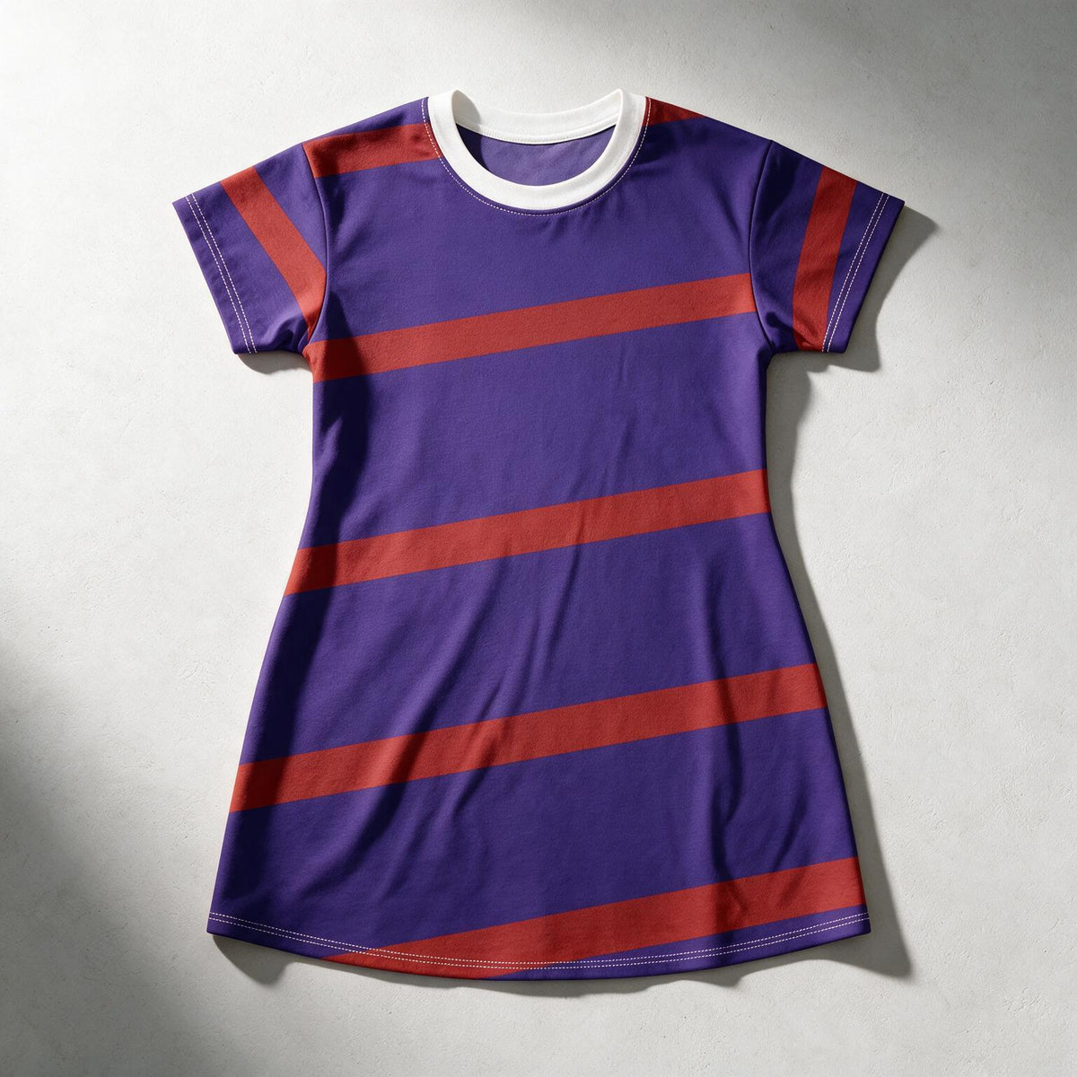 A short-sleeve ringer t-shirt dress in purple with horizontal red stripes and a white crew neck, laid flat on a light gray background.