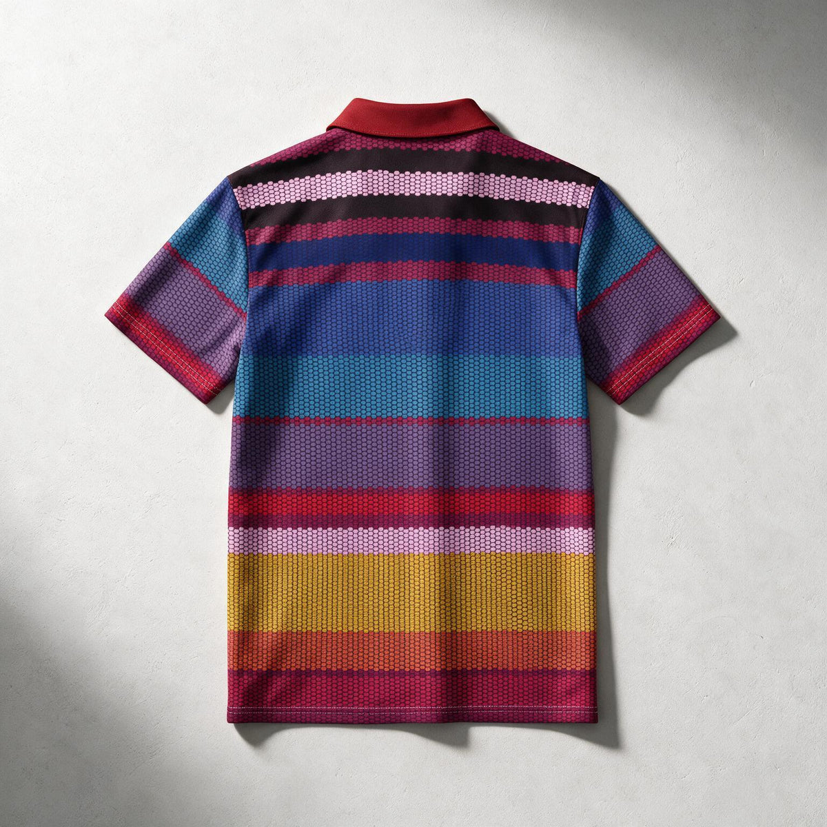 A short-sleeve knit polo shirt shown from the back, featuring a vibrant multicolor horizontal stripe pattern with a solid red collar, laid flat on a light gray textured background.