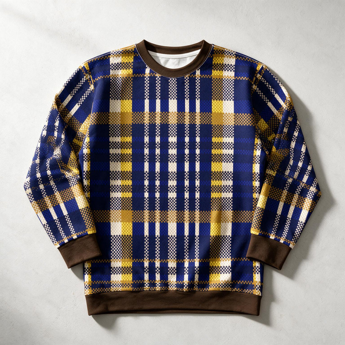 A long-sleeve crewneck sweatshirt featuring a blue, yellow, and white plaid pattern with solid brown ribbed collar, cuffs, and hem, laid flat on a light gray background.