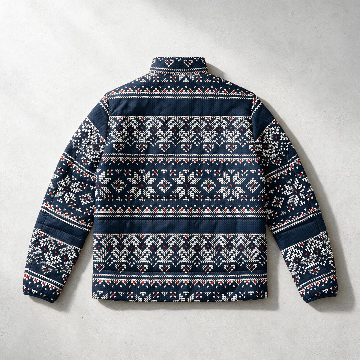A navy blue quilted puffer jacket with a white and red Nordic/Fair Isle pattern, shown from the back against a light gray textured background.