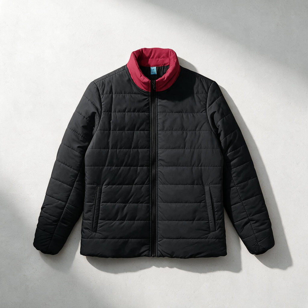 A black quilted puffer jacket with a contrasting red inner collar, displayed flat against a light gray background with soft shadows.