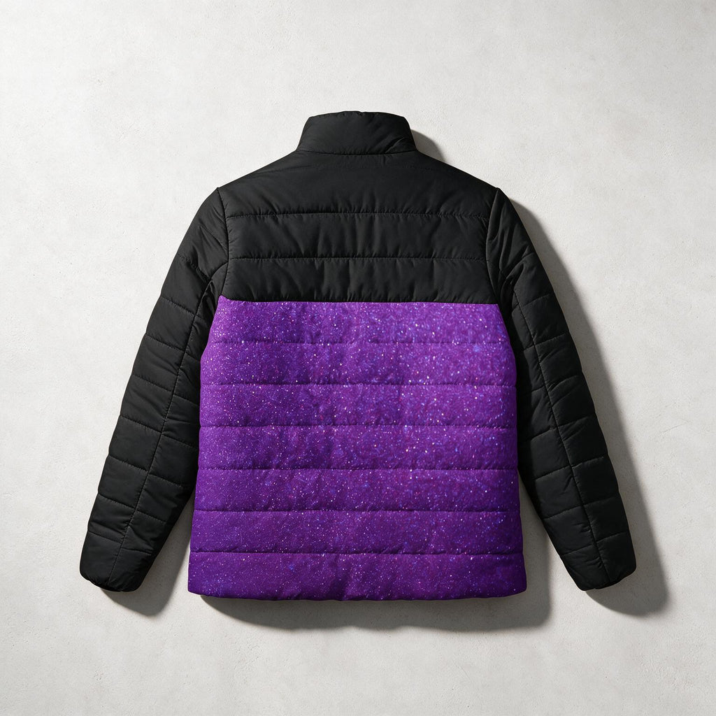 A children's puffer jacket shown from the back, featuring a solid black quilted upper section and sleeves, and a vibrant purple glitter-textured lower section, laid flat on a light gray background.