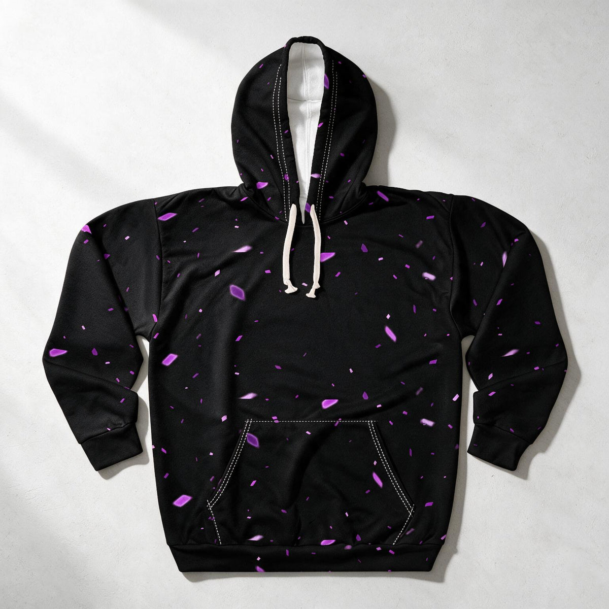 A black pullover hoodie with a scattered purple crystal-like speckle pattern, featuring white drawstrings and a front kangaroo pocket, laid flat on a light gray background.