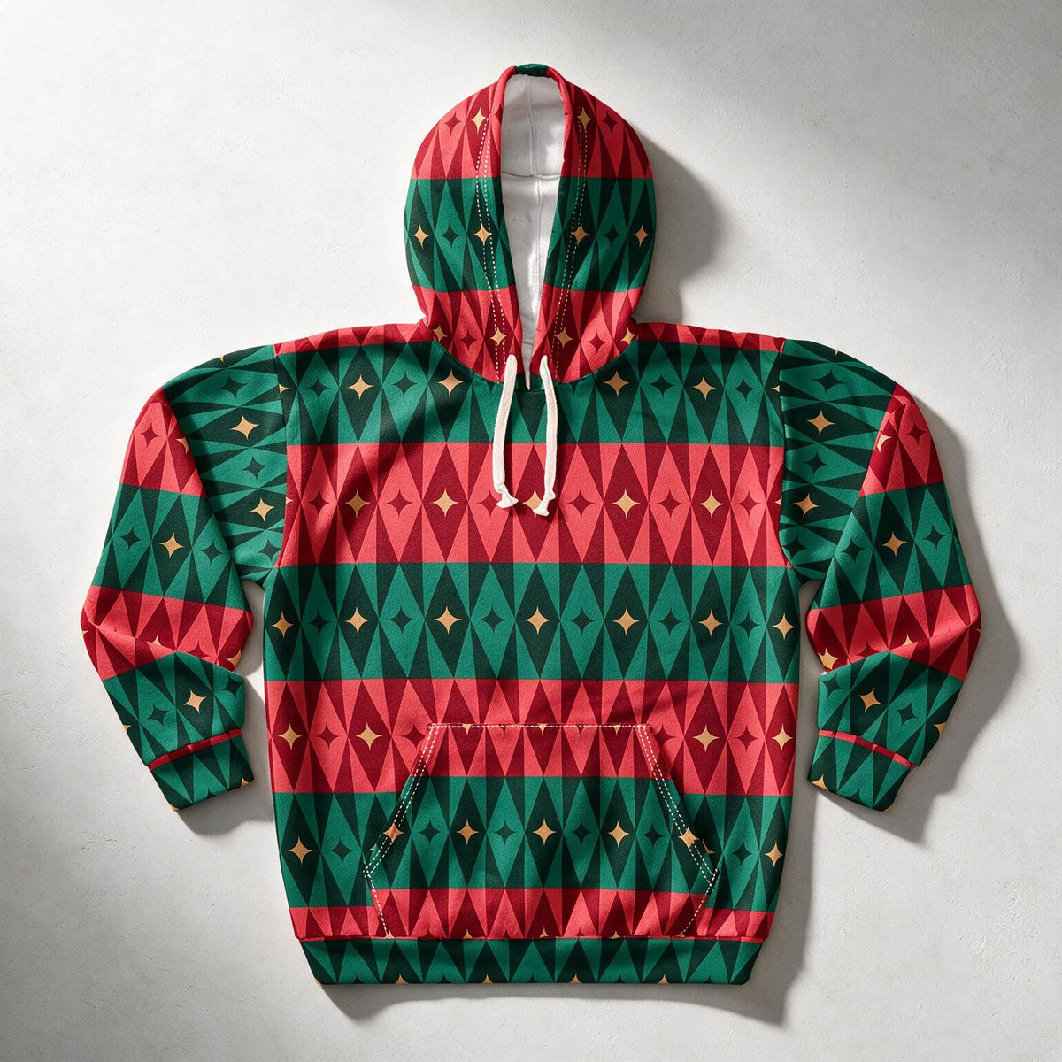 A long-sleeve pullover hoodie with a festive geometric pattern of red and green triangles, accented with small gold stars. The hoodie features white drawstrings and a front kangaroo pocket, laid flat on a light gray background.