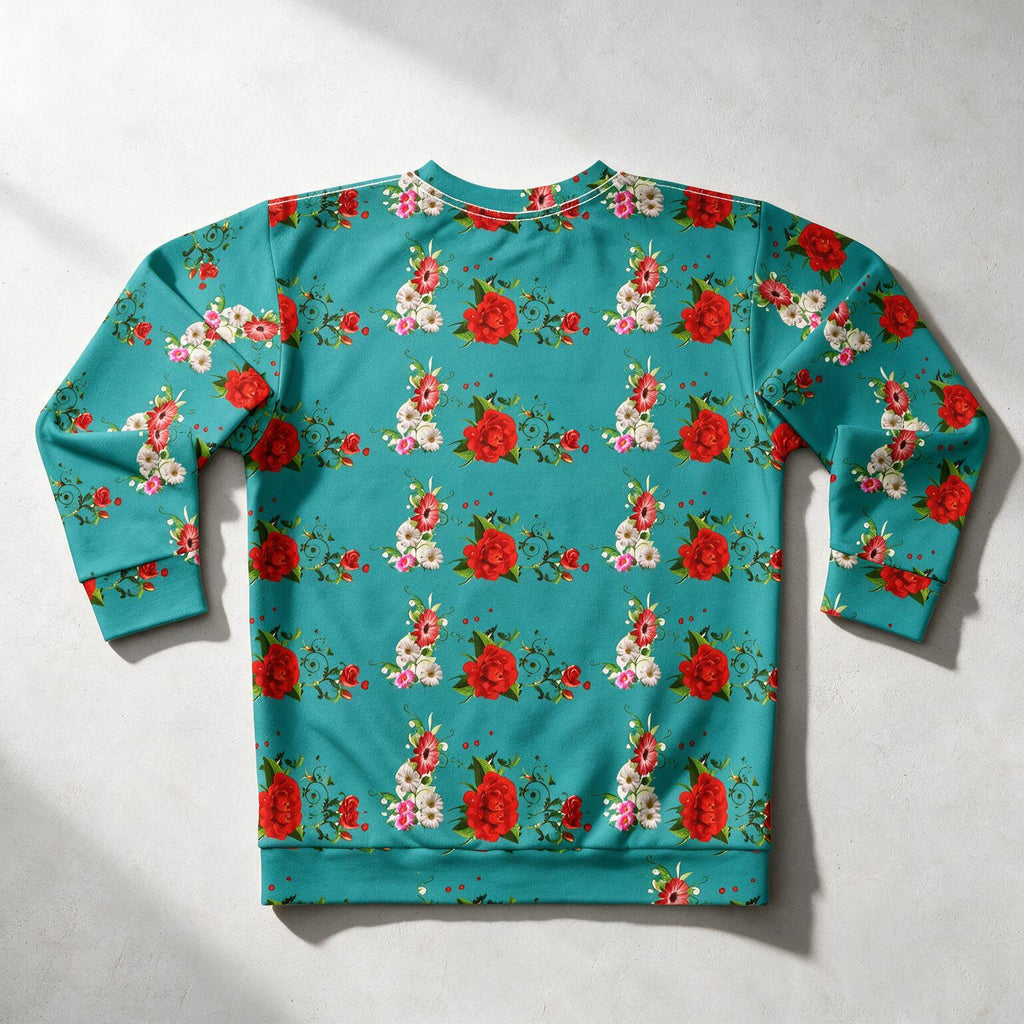 A long-sleeve crewneck sweatshirt featuring an all-over floral print with red roses, white flowers, and green leaves on a turquoise blue background, laid flat on a light gray surface.