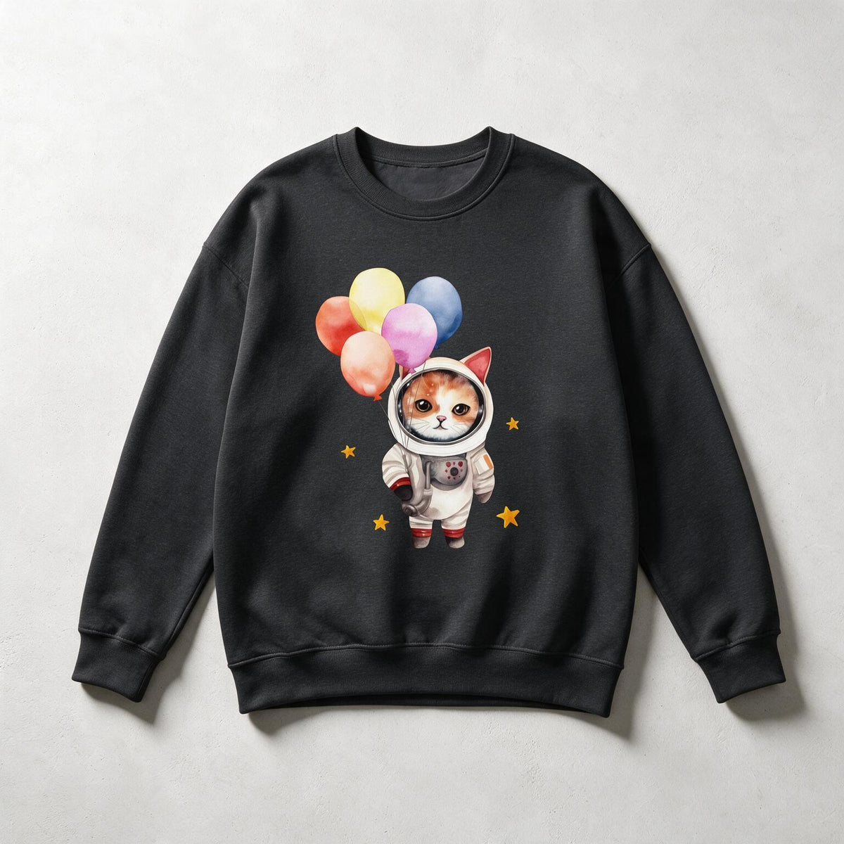 A black crewneck sweatshirt featuring a cute graphic of a cat dressed as an astronaut holding colorful balloons, displayed flat against a light gray background.