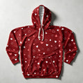 A red pullover hoodie with an all-over pattern of small white and pink hearts, featuring cream-colored drawstrings and a front kangaroo pocket, laid flat on a light gray background.