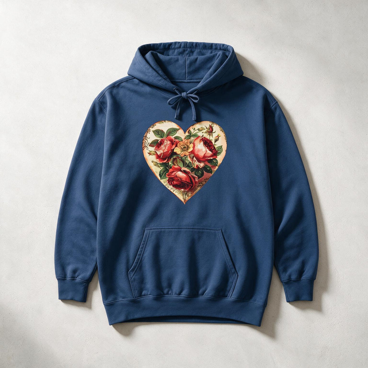 A navy blue pullover hoodie with a front kangaroo pocket and drawstring hood, featuring a large heart-shaped graphic on the chest filled with red roses and green leaves, laid flat on a light gray textured background.