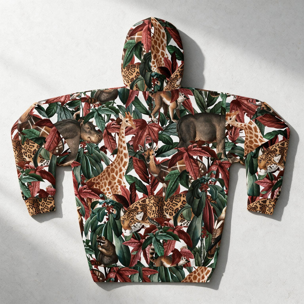 A hooded sweatshirt laid flat on a light gray surface, featuring an all-over safari animal print with giraffes, zebras, leopards, and monkeys among green and red tropical leaves on a white background.
