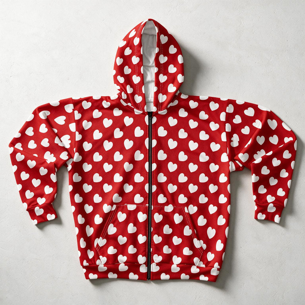 A red zip-up hoodie with an all-over white heart pattern, laid flat on a light gray textured background.
