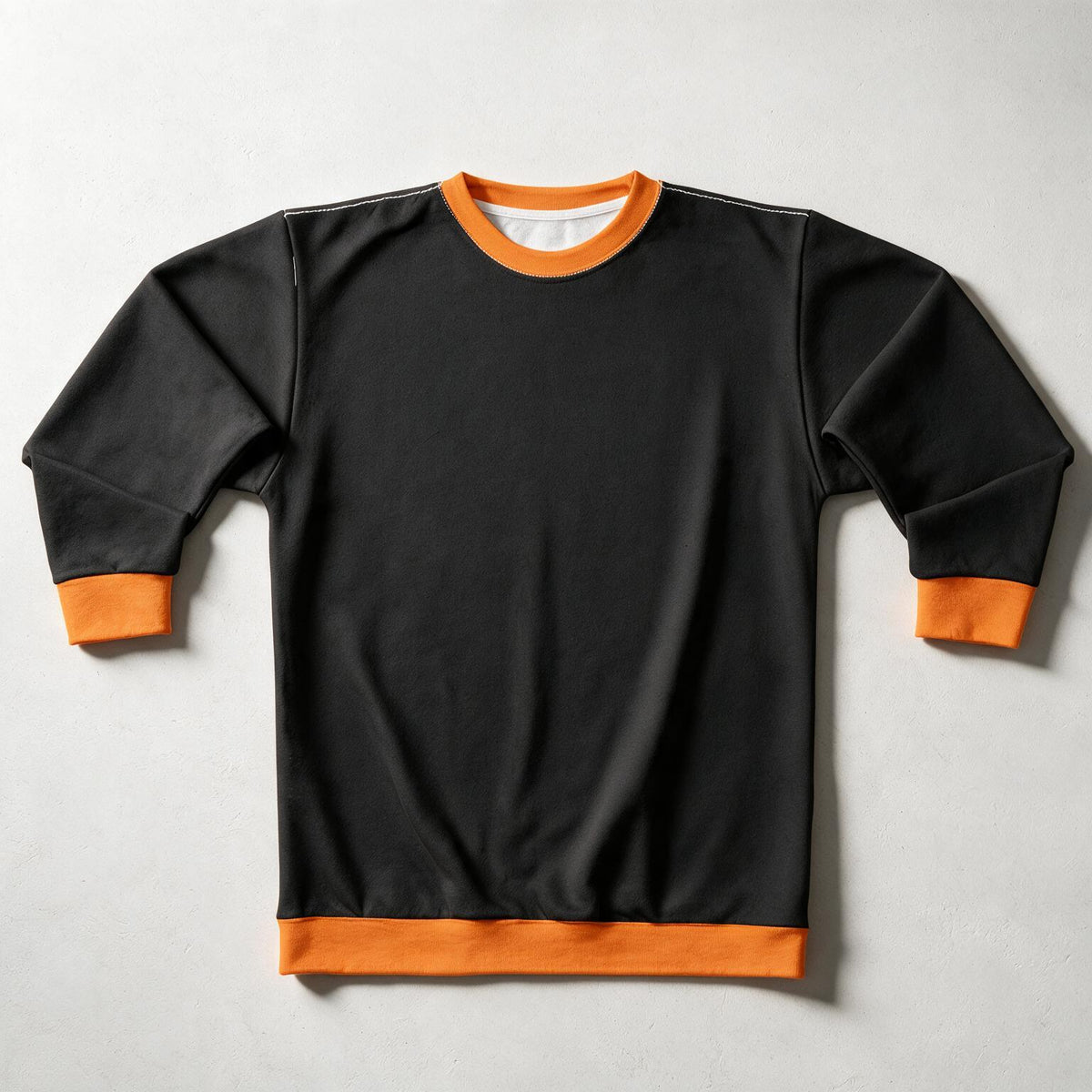 A black long-sleeve crewneck sweatshirt with contrasting orange ribbed trim on the collar, cuffs, and hem, laid flat on a light gray background.