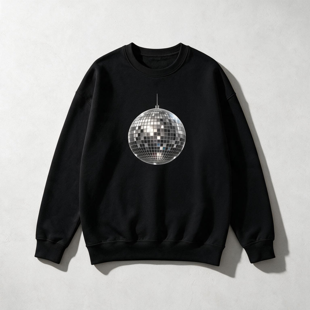 A black crewneck sweatshirt featuring a printed silver and black disco ball graphic on the chest, displayed flat against a light gray textured background.