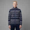 Man wearing a patterned navy sweater against a gray background